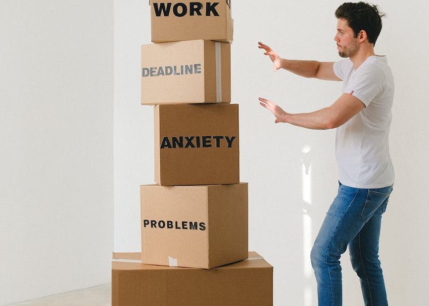 man near carton boxes with many different words about stress